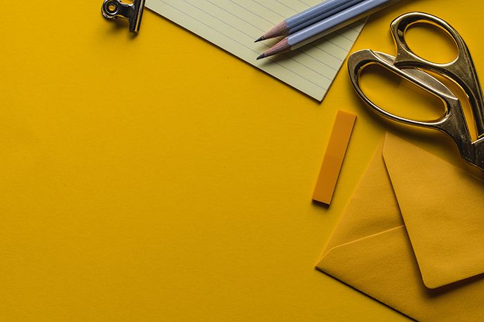 Stationery and envelopes on a yellow desk representing affiliate compliance paperwork