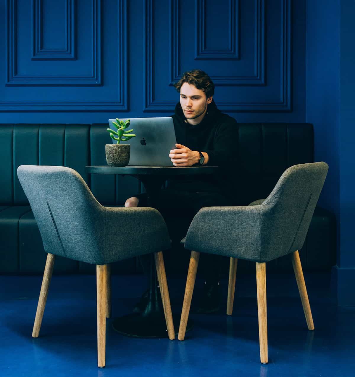 Marketer working on a laptop in a blue room