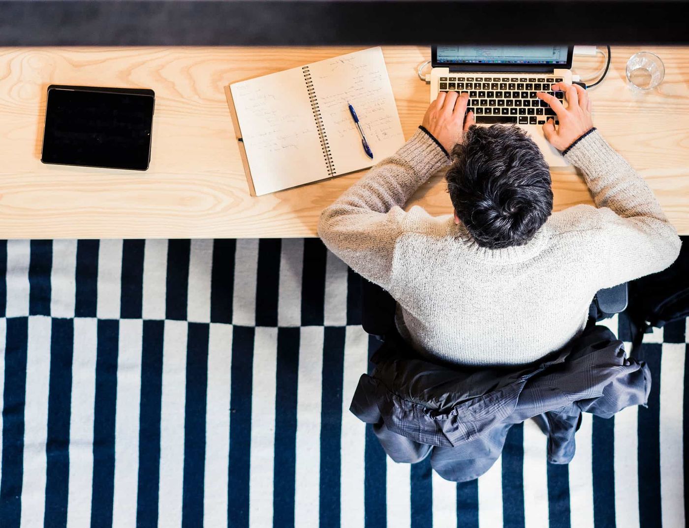 Top-down view of a publisher working on a laptop and reviewing affiliate payouts